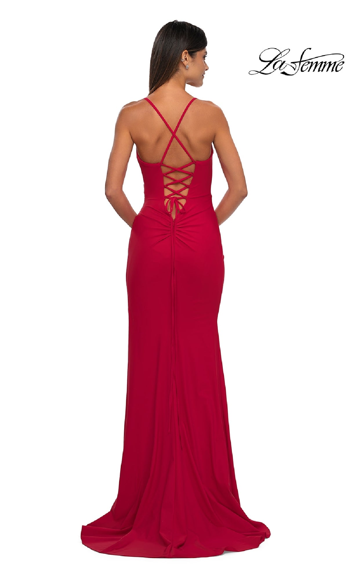 A woman is seen from behind in the Lace-Up Simple Long Prom Dress: La Femme 33103, a floor-length red gown with crisscross straps and a lace-up back. The La Femme logo appears in the top right corner.